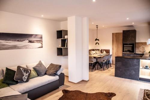 a living room and kitchen with a couch and a table at Apartment Schifta in Chienes