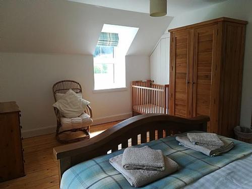 1 dormitorio con 1 cama, vestidor y ventana en Keeper's Cottage en Lochgilphead