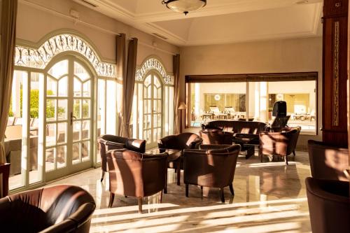 a lobby with leather chairs and tables and windows at TMK Flora Park by Turismark - Adults Only in Hammamet