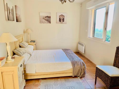 Durban-Corbières的住宿－Chez Noisette，一间卧室配有一张床、一张书桌和一个窗户。