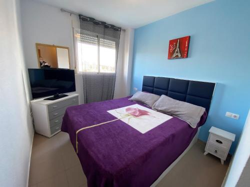 a bedroom with a purple bed and a television at A826 - Niágara - 2004 Finestrat s.l. in Cala de Finestrat