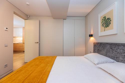 a bedroom with a large bed with white sheets at Cuprum Poilsis in Palanga