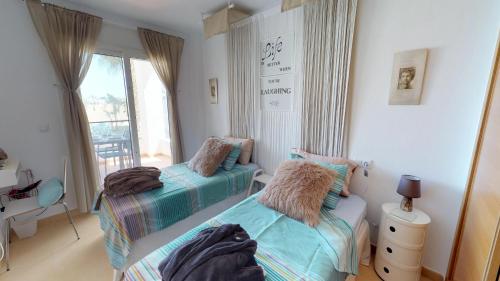 two beds in a room with a window at Casa Arancha - A Murcia Holiday Rentals Property in Roldán