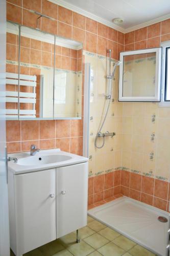 une salle de bain avec un lavabo blanc et une douche dans l'établissement Vacances à 4 à Brem-sur-Mer, à Brem-sur-Mer