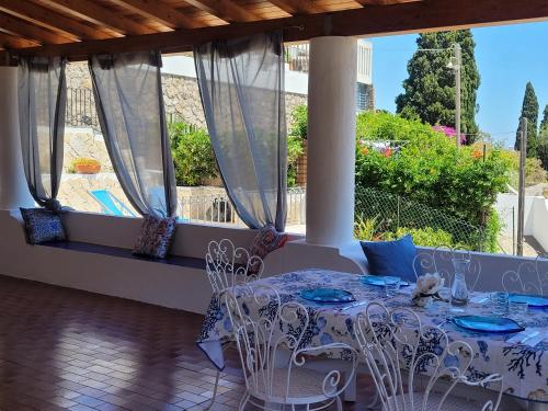 un tavolo e sedie su un portico con vista di Casa Eolie relax a Città di Lipari