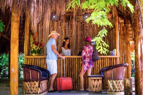a group of people standing around a wooden fence with luggage at Akumal Natura Glamping in Akumal
