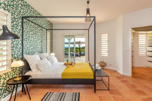 Un dormitorio con una cama grande con una manta amarilla. en Villa du Cap 5 étoiles piscine spa et vue mer exceptionnelle, en Sainte-Anne