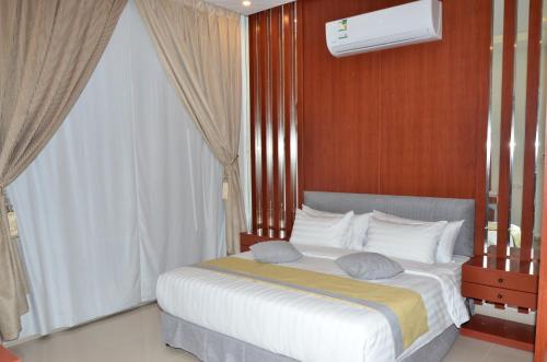 Un dormitorio con una cama grande y una ventana en سماية للأجنحة الفندقية en Riad