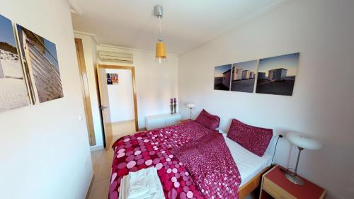 een slaapkamer met een bed met een rood dekbed bij Villa Pino Tea - A Murcia Holiday Rentals Property in Los Alcázares