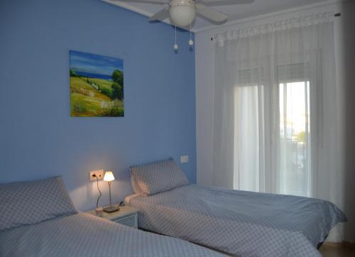 a blue bedroom with two beds and a window at Casa Emperador - A Murcia Holiday Rentals Property in Roldán