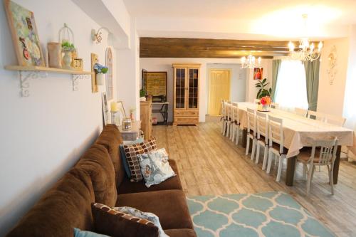 a living room with a couch and a dining room at Vila Chic M in Moieciu de Jos