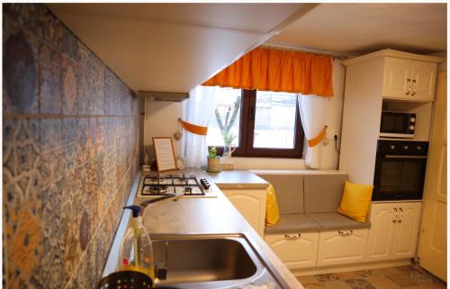 a small kitchen with a sink and a stove at Vila Chic M in Moieciu de Jos