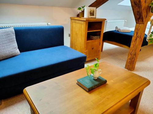 a living room with a blue couch and a coffee table at Casa Dávid Ferenc Ház in Deva