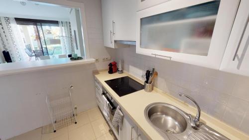 een kleine keuken met een wastafel en een wastafel bij Modern Apt - A Murcia Holiday Rentals Property in Los Alcázares