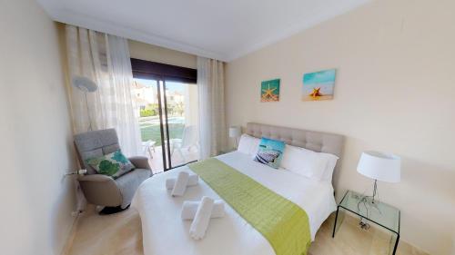 een slaapkamer met een groot wit bed en een stoel bij Modern Apt - A Murcia Holiday Rentals Property in Los Alcázares