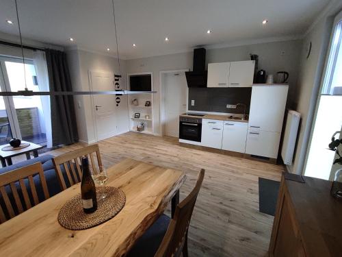 a living room with a wooden table and a kitchen at Ferienwohnung Südkurve in Briedel