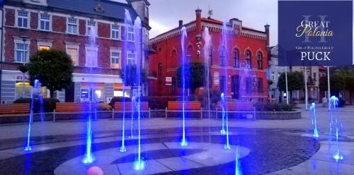 a fountain in front of a building with colorful lights at Great Polonia Beach & Molo in Puck