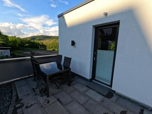 a balcony with a table and chairs and a door at Ferienwohnung Südkurve in Briedel
