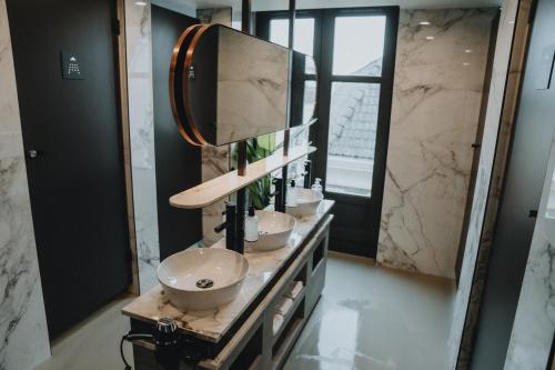 a bathroom with two sinks and a mirror at THIS HO(S)TEL in Amsterdam