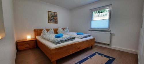 Un dormitorio con una cama con almohadas azules y una ventana en Ferienhaus Gänseblümchen, en Königstein