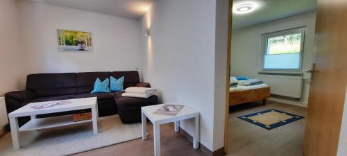 ein Wohnzimmer mit einem Sofa und einem Tisch in der Unterkunft Ferienhaus Gänseblümchen in Königstein an der Elbe