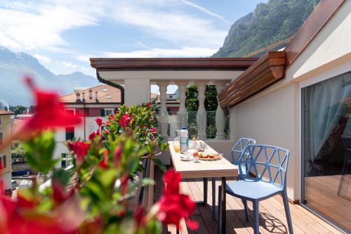 een terras met een tafel en stoelen op een balkon bij lillil - Popping Holiday in Riva del Garda