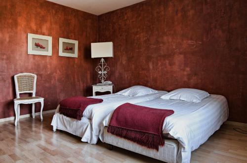 a bedroom with a large bed and a chair at Le Mas Du Pont Roman in Mane