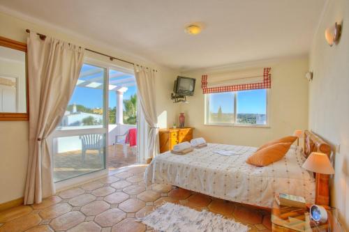 a bedroom with a bed and a view of the ocean at Villa Flor by Villa Plus in Guia