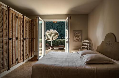 a bedroom with a bed and a door to a patio at Le Mas Du Pont Roman in Mane
