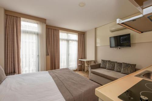 イスタンブールにあるTaksim Peri Suiteのベッドとソファ付きのホテルルーム
