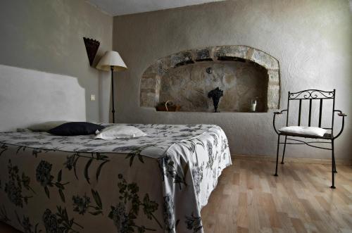 a bedroom with a bed and a chair in it at Le Mas Du Pont Roman in Mane
