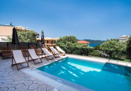 a swimming pool with chaise lounge chairs next to a swimming pool at En Lefko Boutique Apartments in Nikiana