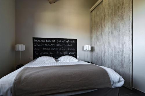 a bedroom with a large bed with a black headboard at Le Mas Du Pont Roman in Mane