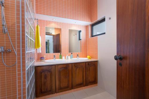 uma casa de banho com dois lavatórios e dois espelhos em Villa Marie Anne by Villa Plus em Carvoeiro