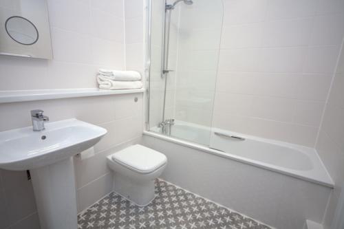 a bathroom with a toilet and a sink and a shower at Highfield Hotel in Houghton le Spring
