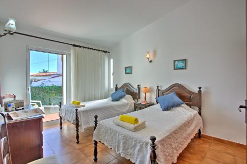 1 Schlafzimmer mit 2 Betten und einem Fenster in der Unterkunft Villa Vitor by Villa Plus in Albufeira