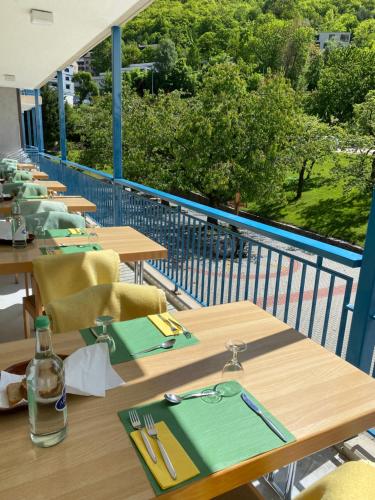 a row of wooden tables and chairs on a balcony at Hotel & Bildungshaus St. Jodern in Visp