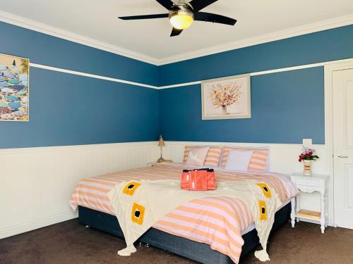1 dormitorio con 1 cama con paredes azules y techo en Charming period cottage with a picturesque garden, en Cowes