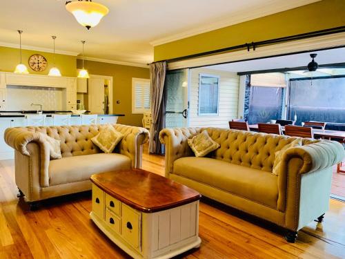 a living room with two couches and a table at Charming period cottage with a picturesque garden in Cowes