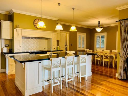 a kitchen with a counter and a bar with stools at Charming period cottage with a picturesque garden in Cowes