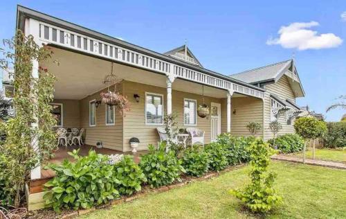 a large house with a garden in front of it at Charming period cottage with a picturesque garden in Cowes