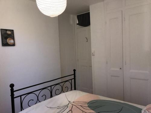 a bedroom with a bed and a chandelier at Chambres individuelles avec partie commune ou logement entier si disponible Via Rhôna in Vulbens