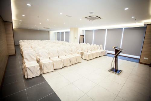 a room with rows of white chairs and a podium at Putatan Platinum Hotel in Kota Kinabalu