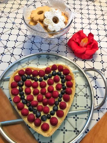 a heart shaped fruit tart on a glass plate on a table at Agriturismo Natta Di Monte Tabor in Celle Ligure