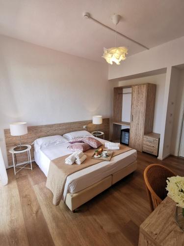 a bedroom with a large bed and a table at Hotel Onda Marina in San Teodoro