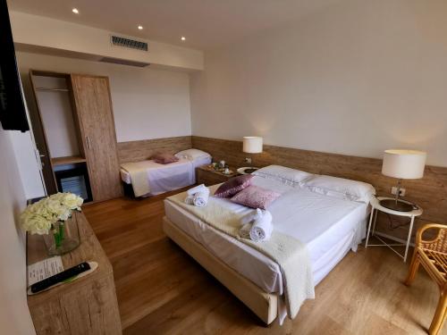 a bedroom with two beds and a table and a table sidx sidx sidx at Hotel Onda Marina in San Teodoro