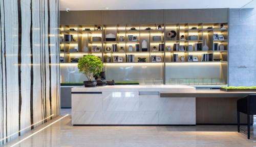 a lobby with a counter with a plant on it at Crowne Plaza Shenzhen World Exhibition and Convention Center by IHG in Shenzhen