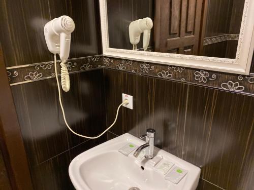a bathroom with a sink and a phone on the wall at NESS готельно-ресторанний комплекс in Luts'k