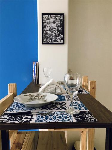 - une table en bois avec une assiette et des verres à vin dans l'établissement FyD Apart, à San Miguel de Tucumán