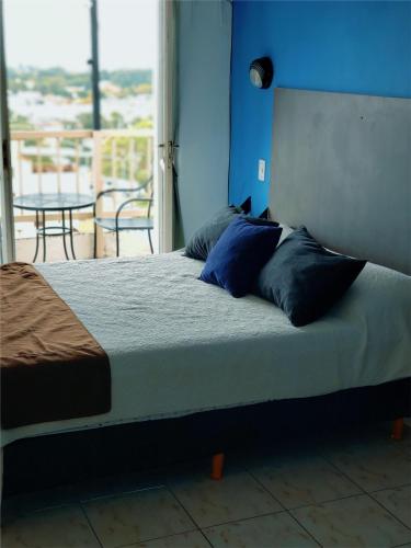 Cette chambre comprend un lit avec des murs et des oreillers bleus. dans l'établissement FyD Apart, à San Miguel de Tucumán